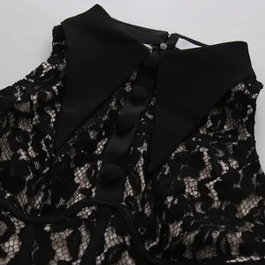 Vista detallada de un vestido de encaje floral negro con cuello puntiagudo y botones forrados.