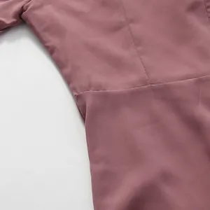 Close-up of high-quality dusty pink crepe fabric and waist stitching on a French dress