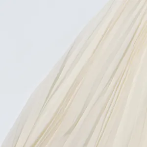 Close-up detail of elegant off-white pleated chiffon fabric texture for a maxi dress