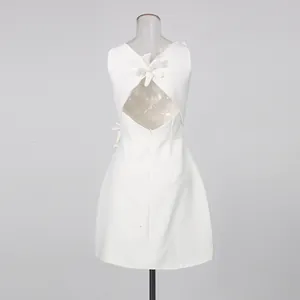 Back view of white sleeveless mini dress featuring 3D floral applique and cutout
