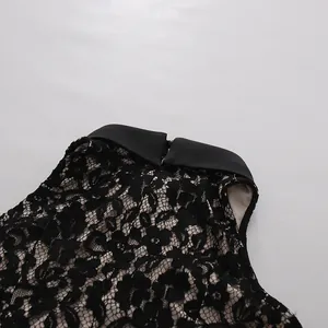 Detalle del escote del vestido de encaje negro con un elegante cuello de punta