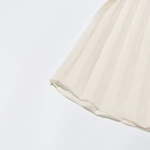 Detailed macro view of white pleated hem on high-end elegant long dress