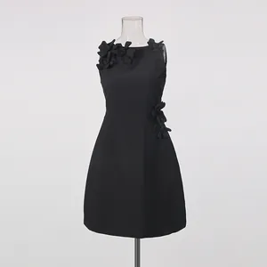 Close-up of black sleeveless dress featuring 3D floral appliques and round neckline