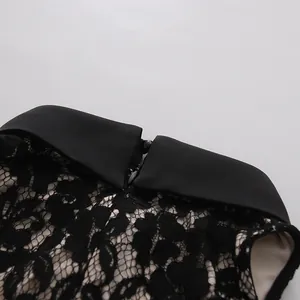 Vista de cerca del delicado tejido de encaje negro y del elegante cuello en punta