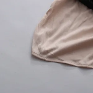 Detalle del forro de satén beige liso y las costuras impecables del vestido de encaje.