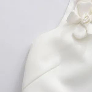 Close-up detail of exquisite 3D flower applique on elegant white sleeveless dress