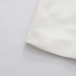 Macro view showing the high-quality white woven fabric texture of the minimalist dress
