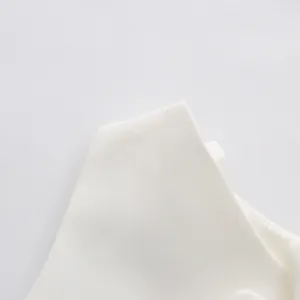 Detailed close-up showing the premium white fabric texture of a sleeveless fashion dress.
