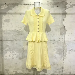 Front view of yellow knit dress with peplum waist and lace embroidery details