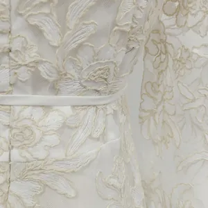 Close-up detail of exquisite floral water-soluble embroidery and delicate lace on a white dress