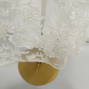 Detail of high-end water-soluble embroidery floral lace on a white French evening dress
