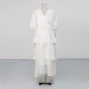 Vintage white V-neck tiered dress with puff sleeves and lace trim on mannequin
