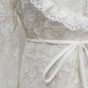 Detailed macro shot of French-style white lace dress with water-soluble embroidery