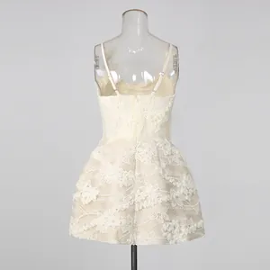 Back view of a chic cream lace embroidered mini dress with thin straps and floral pattern