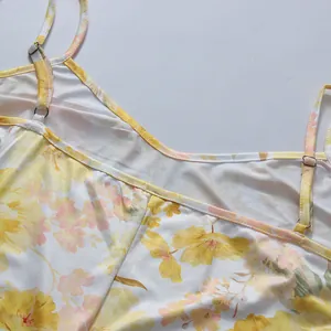 Detailed close-up of adjustable spaghetti straps and yellow floral print on a summer dress