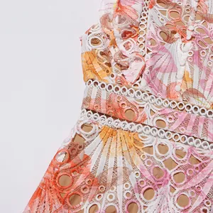 Gros plan de la broderie en dentelle guipure blanche sur une robe fleurie sans manches