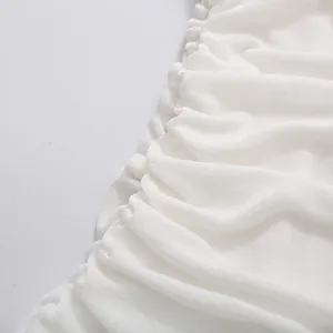 Close-up detail of elegant white ruched fabric texture on sleeveless dress