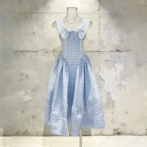 Vista frontal de vestido midi a cuadros azul claro sin mangas con lazo y encaje fino