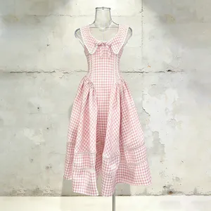 Detalle de un vestido vichy rosa y blanco con un cuello de encaje y un lazo