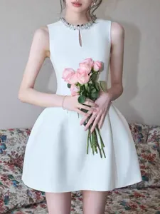 Elegant white sleeveless dress featuring a rhinestone neckline and flattering A-line silhouette