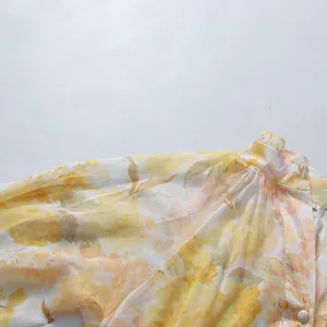 Detailed macro view of a romantic floral dress featuring lantern sleeves and ruffled collar
