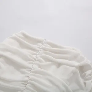 Detailed close-up view of the fine ruched fabric and hidden zipper on this white dress
