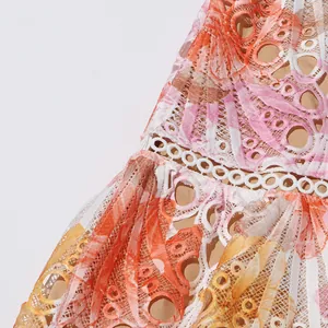 Gros plan sur la broderie en dentelle aux motifs de coquillages d'une robe d'été chic.