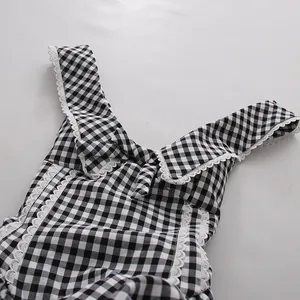 Detalle de un vestido a cuadros blanco y negro con encaje y adorno de lazo.