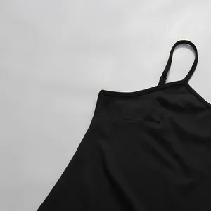 Détail d'une robe noire de style français avec une fine bretelle ajustable.