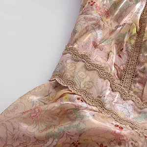 Close-up view of vintage floral print fabric featuring intricate gold lace trim details