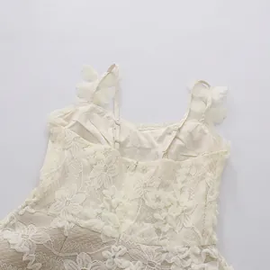 Close-up of exquisite lace texture and 3D floral appliques on cream dress straps