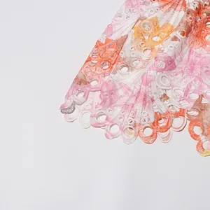 Vue macro détaillée de broderies florales colorées et de dentelle délicate sur cette robe d'été