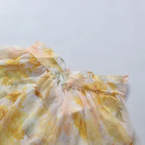 Close-up detail of romantic yellow floral pattern on a lightweight chiffon dress collar