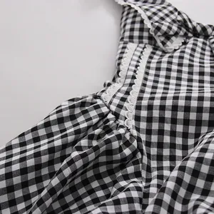 Detalle de vestido de cuadros vichy blanco y negro con encaje y textura de tela