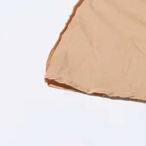 Vue détaillée de la couture de haute qualité et du tissu d'un ourlet de robe beige