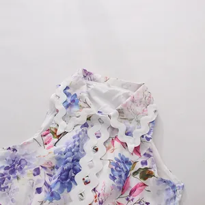 Close-up detail of a floral sleeveless dress with white wavy ric-rac trim and buttons