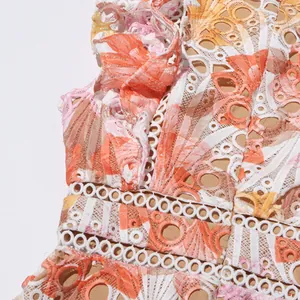 Détail d'une robe en dentelle florale brodée avec des manches à volants et motifs
