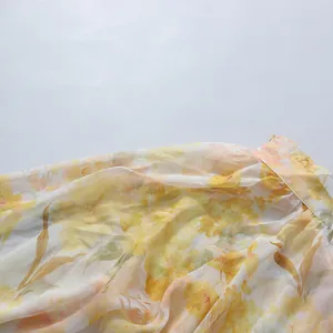 Detailed close-up showing the delicate yellow floral pattern on light airy chiffon dress