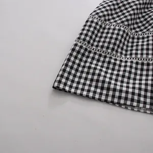 Detalle de un vestido de cuadros vichy blanco y negro con delicado encaje blanco