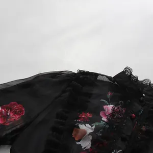 Vue détaillée d'une robe en mousseline noire à fleurs avec des volants en dentelle