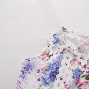 Close-up of white floral summer dress with elegant wavy scallop edge collar detail