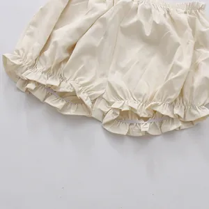 Detailed view of cream ruffled hem bloomers featuring delicate elastic frill trim