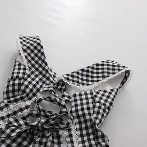 Primer plano de vestido de cuadros blanco y negro con encaje blanco y lazo.