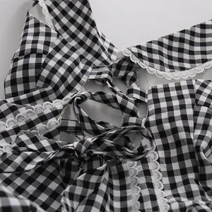 Primer plano de un vestido de cuadros blancos y negros con encaje y lazo en la espalda