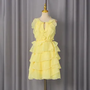 Elegant yellow sleeveless dress with tiered ruffle details on a gold mannequin.