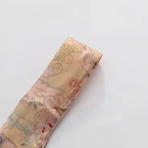 Close-up detail of the vintage floral print fabric with silky satin finish and soft colors