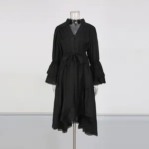 Détail d'une robe noire brodée style cour française avec manches évasées et dentelle.