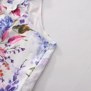 Close-up view of a floral sleeveless dress featuring a side zipper and white wavy trim