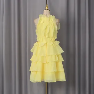 Close-up detail of yellow sleeveless mini dress featuring tiered ruffles and ruffled bodice