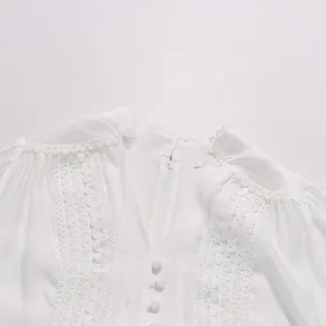 Détail de la robe blanche style cour française avec broderie et boutons décoratifs.